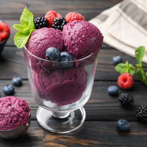 3 scoops of blueberry sorbet in a small glass dish