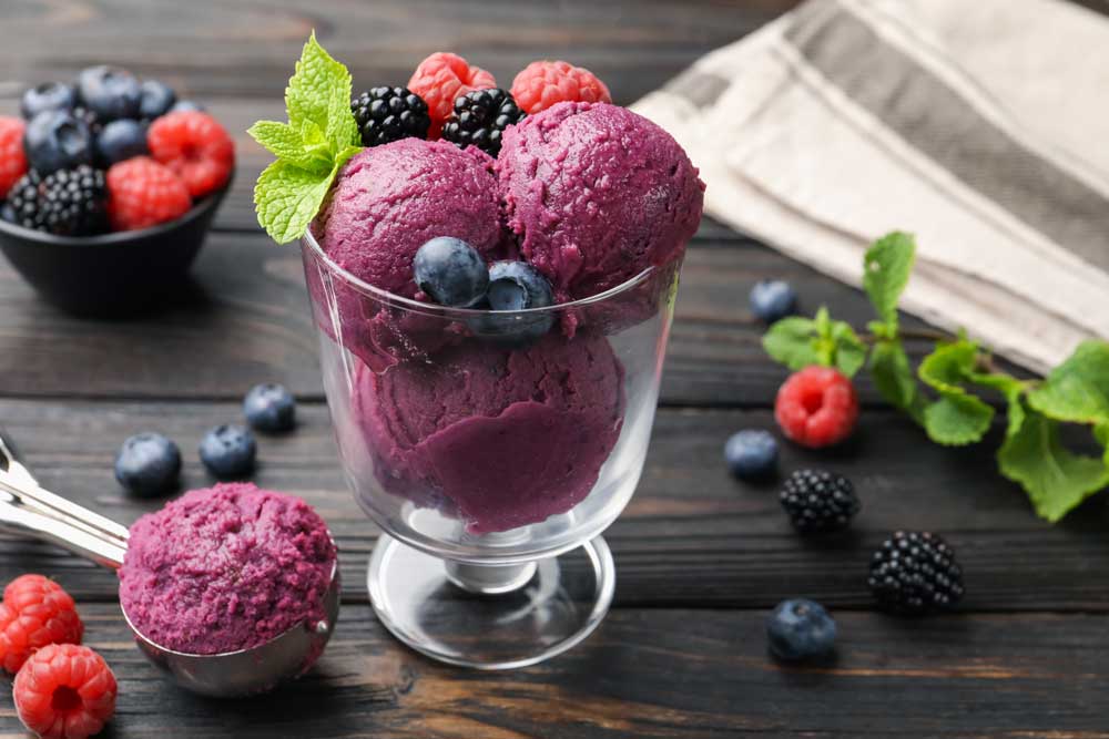 3 scoops of blueberry sorbet in a small glass dish
